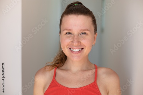 Portrait of happy cheerful positive girl, young joyful woman is smiling at home at sunny day, looking at camera on white background 