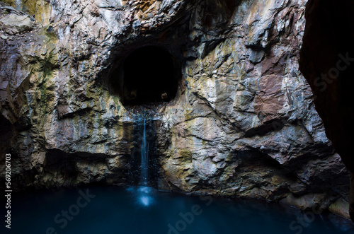 The Blue cave in Klackberg is an abandoned mine in Norberg, Long exposure photograph of water dripping from an abandoned iron shaft to rock grotto filled with blue water photo