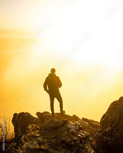 A man standing on a stone at sunrise on Jested in the Czech Republic.