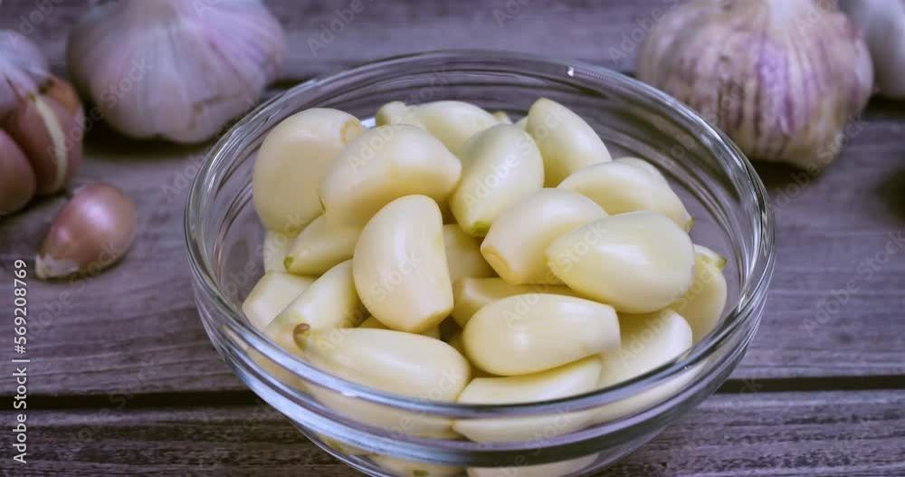 Fresh peeled garlic clove in glass bowl. The raw garlic is one of the most popular ingredients