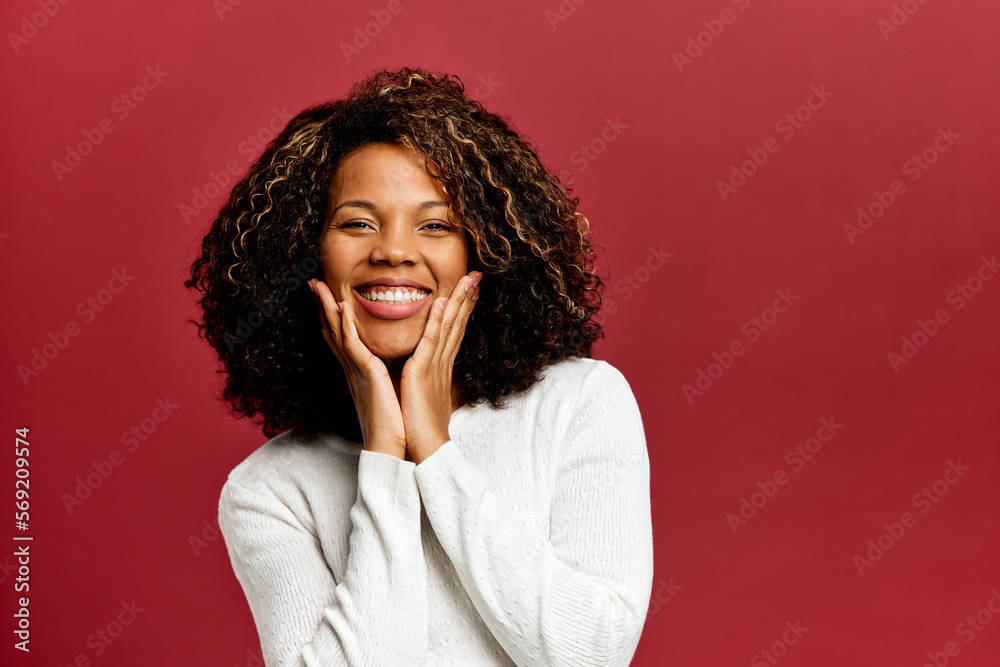 Portrait of a smiling African woman, touching cheeks with hands. Portrait of a smiling African woman, touching cheeks with hands.