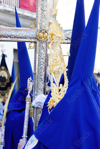 Penitent or Nazarene carrying a cross in the procession of Palm Sunday.