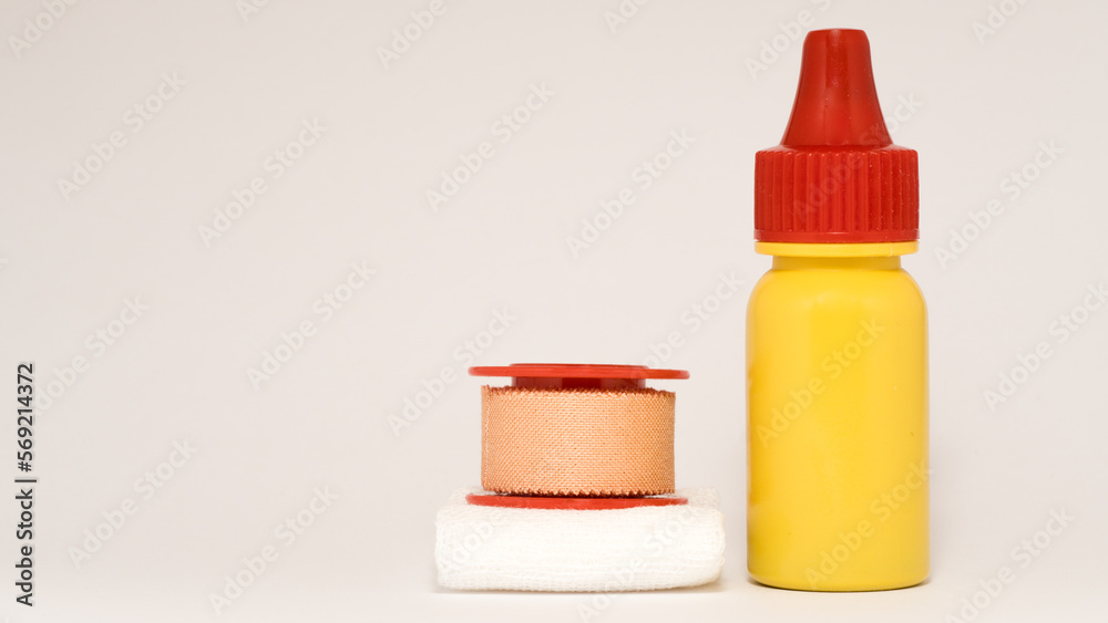 macro photo of first aid equipment for wound: plaster, gauze and iodine isolated on white background