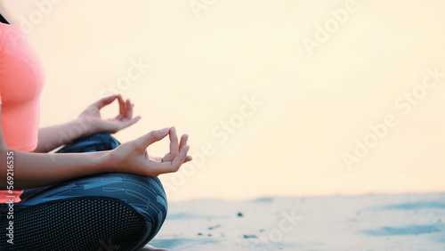 Healthy  young beautiful woman meditating  practicing yoga on the beach  by the sea  at sunrise  Relaxes muscles  mind  acquires the harmony of soul and body. close up