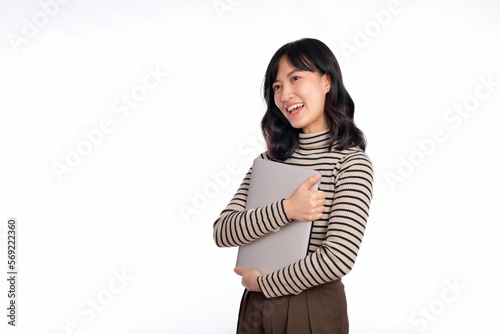 Beautiful young Asian woman on sweater clothing holding laptop pc computer and looking at camera with smile face, isolated on white background