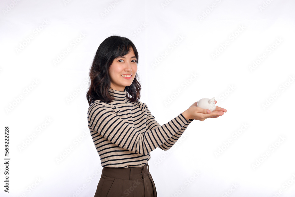 Portrait of young Asian woman casual uniform holding white piggy bank isolated on white background, Financial and bank saving money concept Portrait of young Asian woman casual uniform holding white piggy bank isolated on white background, Financial and bank saving money concept
