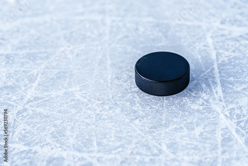 black hockey puck lies on ice at stadium