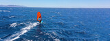 Aerial drone ultra wide panoramic photo with copy space of wind surfer cruising in high speed in tropical ocean bay with deep blue see