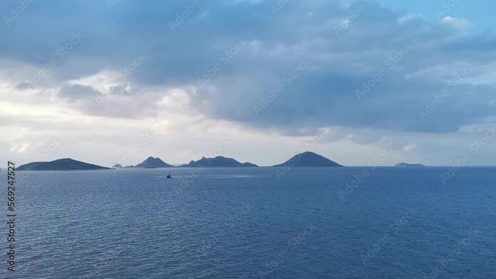 Aegean sea with islands and sunset through cloudy sky Aegean sea with islands and sunset through cloudy sky