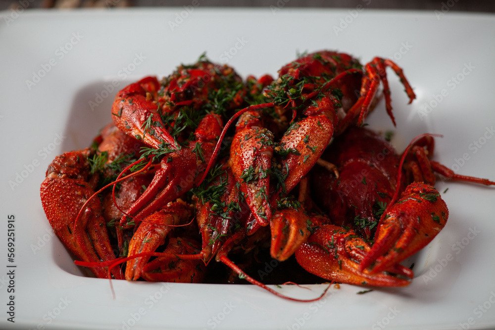 A lot of pickled boiled crawfish in sauce on a plate A lot of pickled boiled crawfish in sauce on a plate