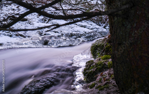 Beauty of a stream in the forest in winter in Finland