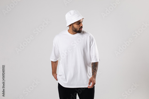 Attractive african american man with a beard dressed in a white t-shirt and panama.