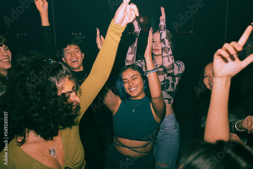 Cheerful young friends dancing and enjoying together at nightclub
