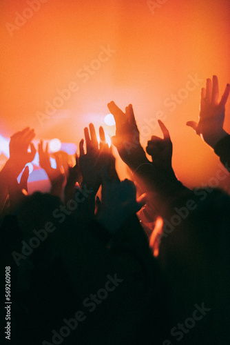 Silhouette raised hands of men and women dancing at nightclub