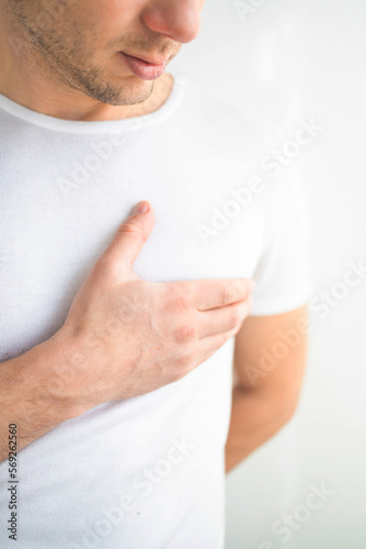 Breathing problem. Sick middle-aged man with chest pain touching inflammated zone and looking at copy space, grey studio background. Bearded man suffering from pneumonia or asthma. COVID-19 concept photo