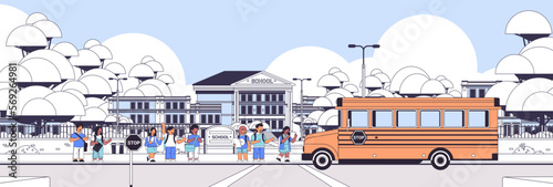 Group of mix race pupils walking to school building from yellow bus primary schoolchildren students cityscape