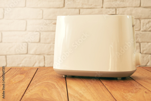 Modern white electric toaster for bread on the wooden kitchen table. Cooking and homeware technologies