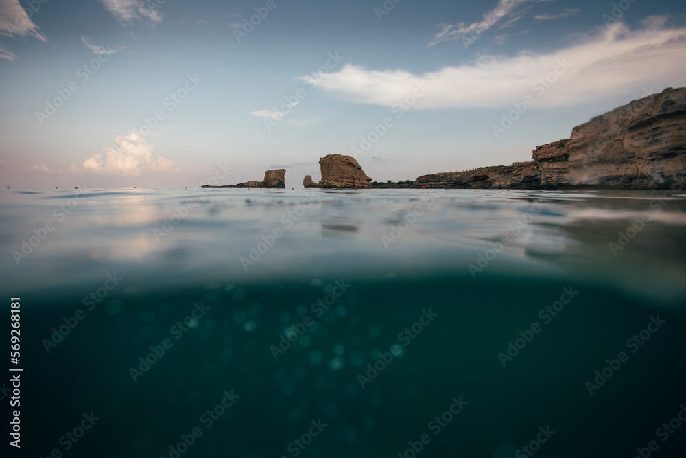 Half underwater shot of sea rocks near coastline