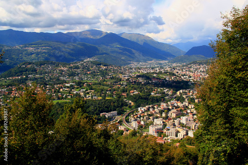 Panoramic view of the mountains  and a city at their feet from Mount San Salvatore in the city of Lugano, in southern Switzerland	