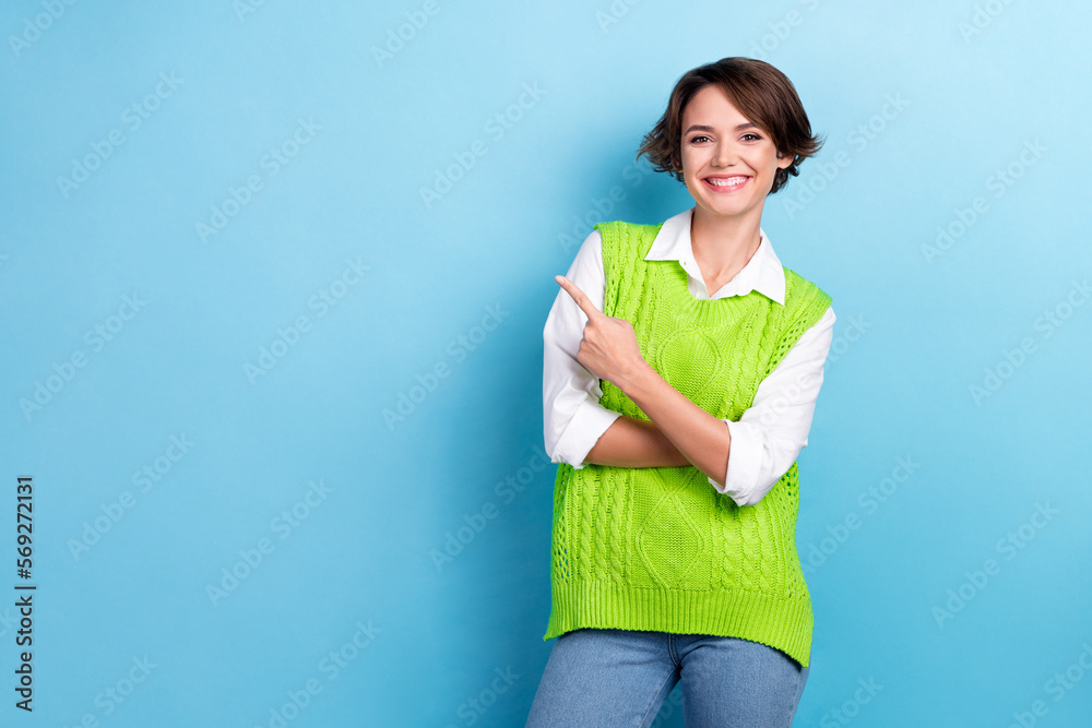 Photo of young optimistic attractive business lady wear knit green vest indicate finger empty space it school promo isolated on blue color background Photo of young optimistic attractive business lady wear knit green vest indicate finger empty space it school promo isolated on blue color background