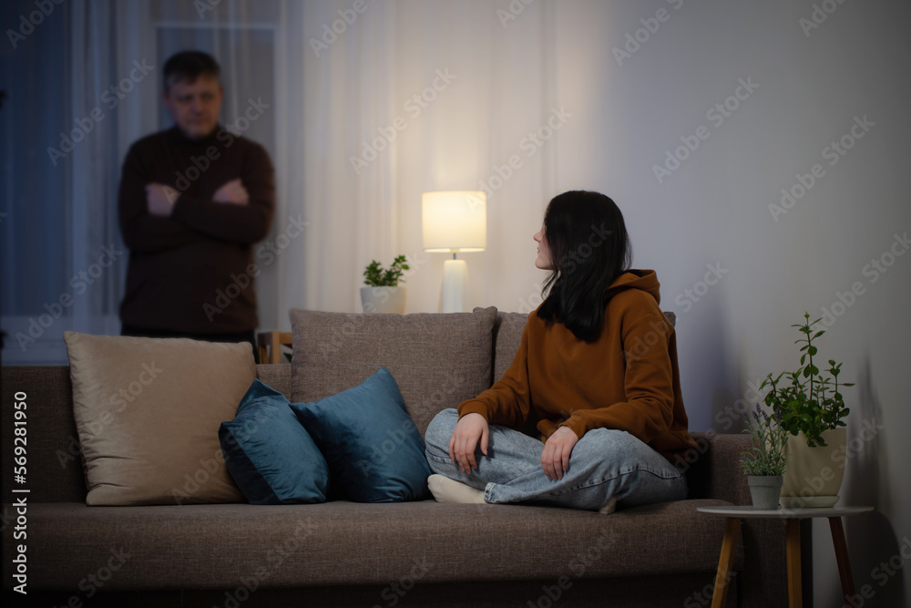 father and daughter teenager in living room in evening, concept of problems in family father and daughter teenager in living room in evening, concept of problems in family