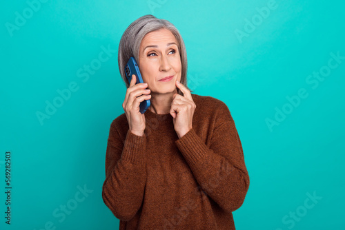 Portrait of minded person finger touch chin speak telephone brainstorming isolated on emerald color background