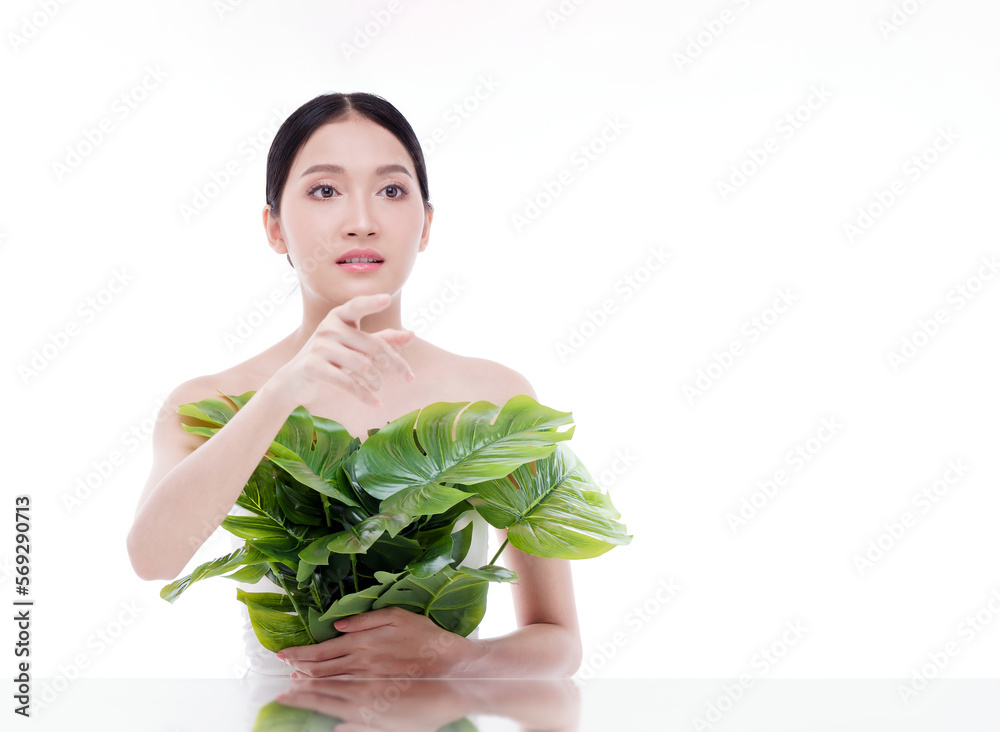 Studio shot. Beautiful asian woman with green plant isolated on white background. She was looking at something with suspicion. Studio shot. Beautiful asian woman with green plant isolated on white background. She was looking at something with suspicion.
