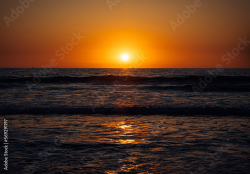 Beautiful sunset over the sea. Rays of the sun touches surface of the calm sea. Meditative atmosphere.