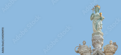 Banner with ancient statue of Maria with cross and holy grail at the roof top decoration of Doge Palace in Venice, Italy, at blue sky background with copy space. Concept of architecture heritage sites