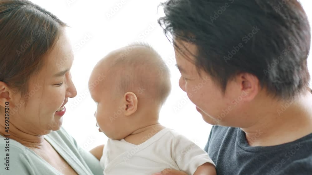 Asian parents kissing new born baby with love and warm Asian parents kissing new born baby with love and warm