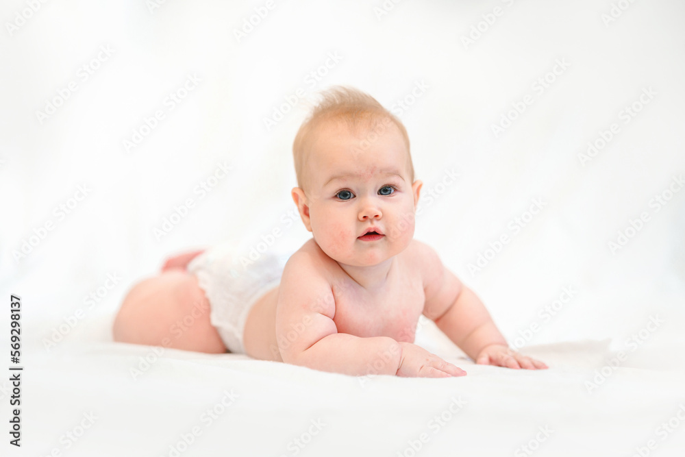 Beautiful Little Caucasian baby in a diaper on a white background