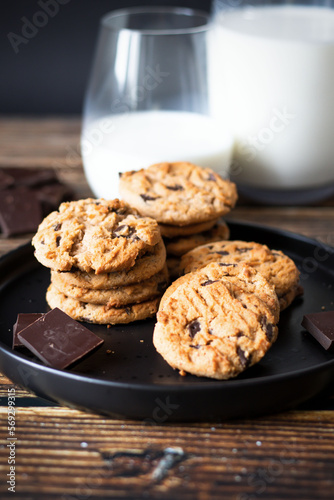 Chocolate cookies with pieces of chocolate on a wooden background