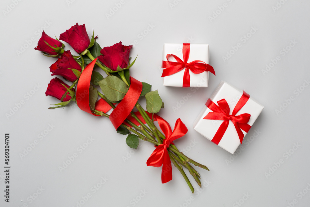Valentines day gifts with red roses on color background, top view Valentines day gifts with red roses on color background, top view