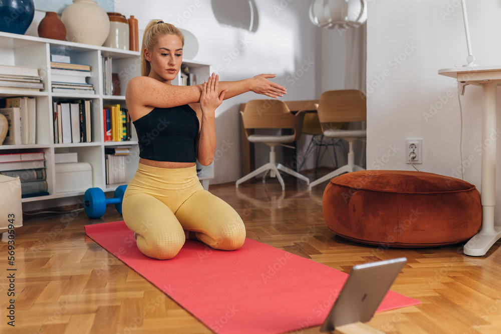 Young beautiful woman stretches her arms on the mat Young beautiful woman stretches her arms on the mat