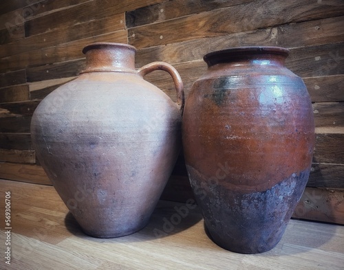 vintage earthenware jugs on the background of a wooden wall