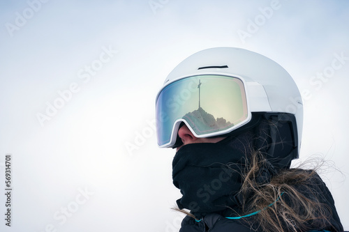 Skifahrerin mit weißen Helm und Gipfelkreuz Reflexion in der Brille photo