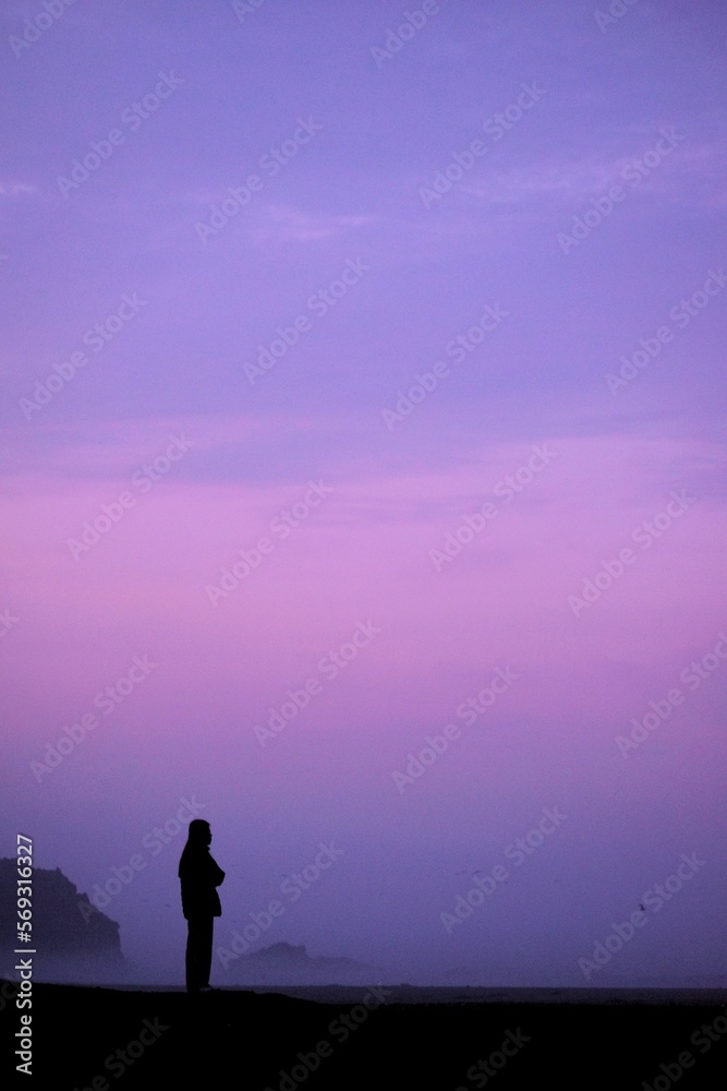 silhouette of a person standing on a cliff