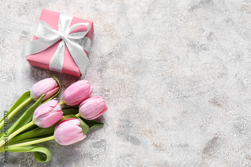 Beautiful tulip flowers and gift box on light background