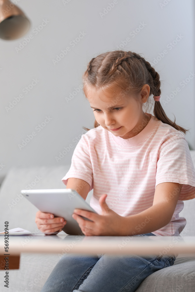 Upset little girl video chatting with psychologist on tablet computer at home