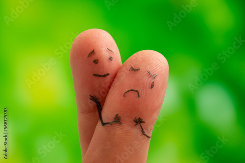 Relationship concept. Woman cries, man reassures her. Fingers