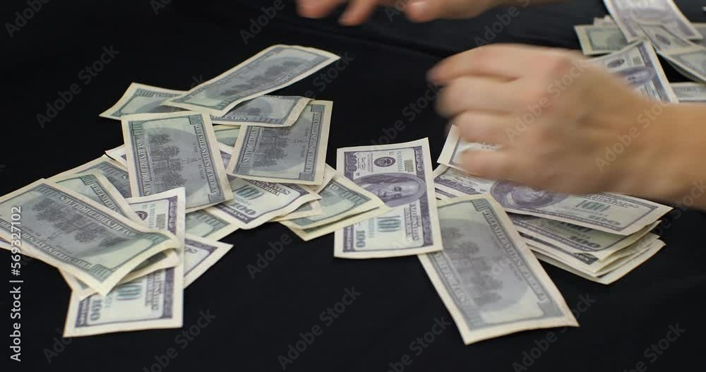 Video Stock Women's hands are raking one hundred dollar bills from the