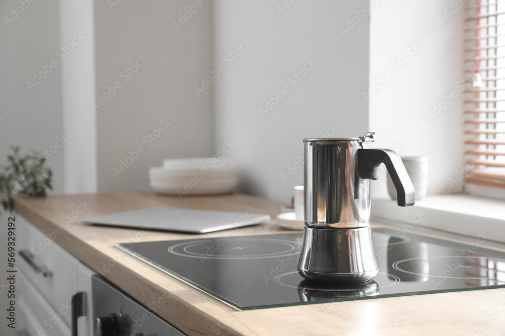 Geyser coffee maker on electric stove in kitchen near window Geyser coffee maker on electric stove in kitchen near window