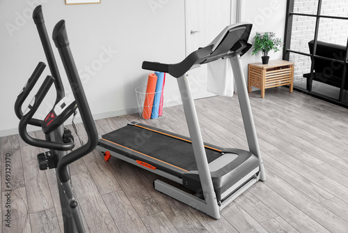 Interior of gym with modern treadmill and sport equipment