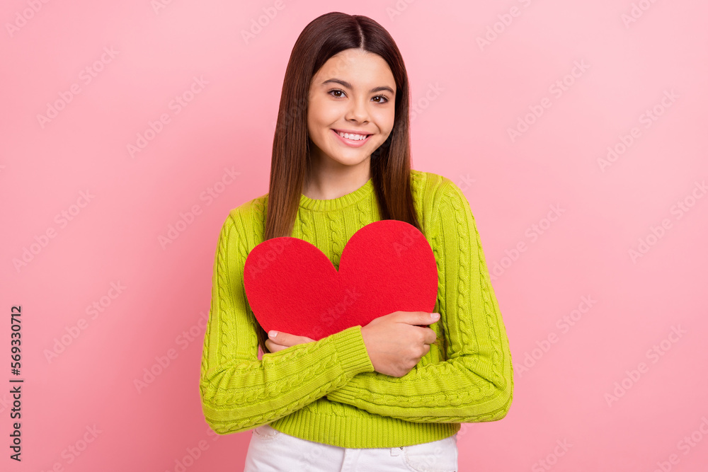 Portrait of cheerful nice girl beaming smile arms hold red paper heart card isolated on pink color background Portrait of cheerful nice girl beaming smile arms hold red paper heart card isolated on pink color background