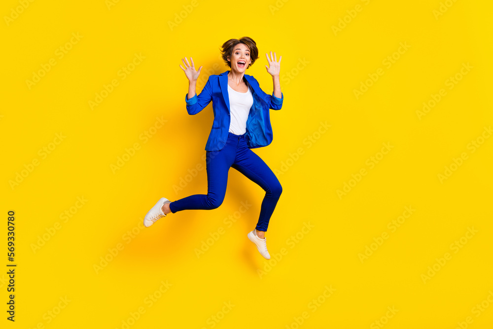 Full length photo of pretty impressed lady dressed blue blazer jumping high rising hands arms isolated yellow color background