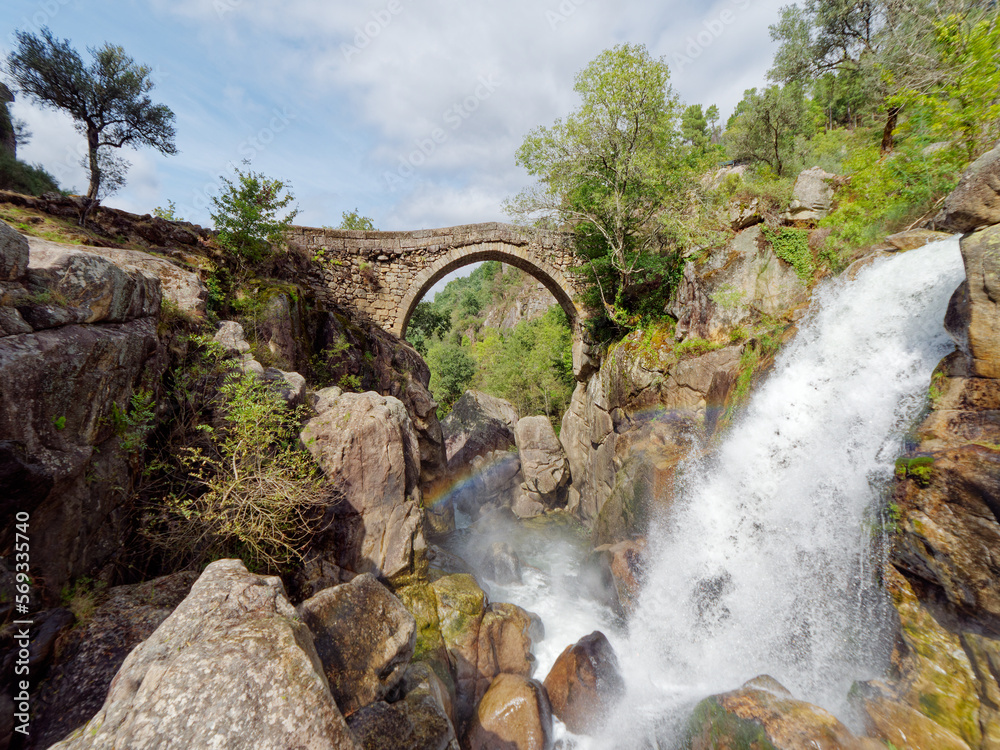 Ponte da Misarela or Bridge of Mizarela in Montalegre, Portugal with a big waterfall next to it during a sunny day. Rural travel and holidays in nature. Ponte da Misarela or Bridge of Mizarela in Montalegre, Portugal with a big waterfall next to it during a sunny day. Rural travel and holidays in nature.