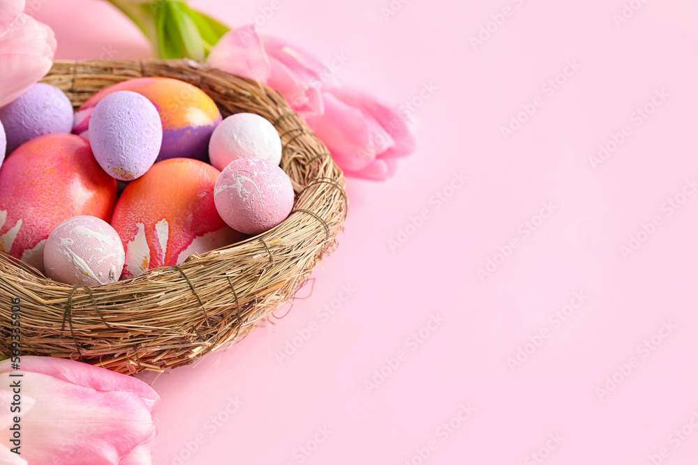 Nest with beautiful Easter eggs and tulip flowers on pink background Nest with beautiful Easter eggs and tulip flowers on pink background