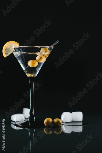 Drink martini. Martini with olives on a black table. Free space for text.