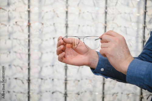 Man evaluating quality of glasses in optical shop