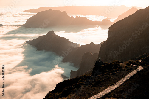 Pico do Arieiro is the third highest peak on Madeira Island and is one of the most popular sunrise spots.,a view from a drone of a landscape shrouded in clouds photo